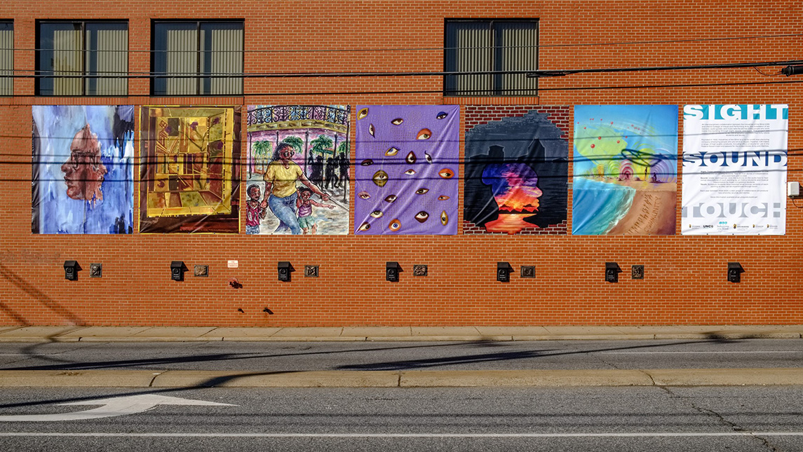 Artwork displayed on Industries for the Blind Building shows images on banners